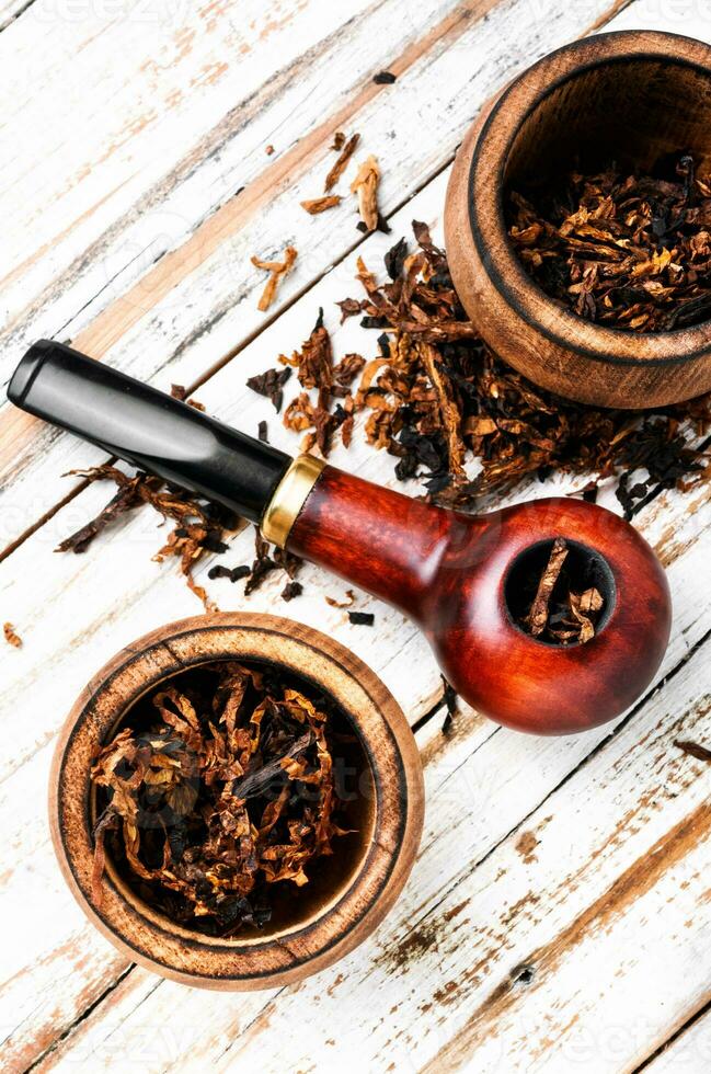 Smoking pipe on a wooden table photo