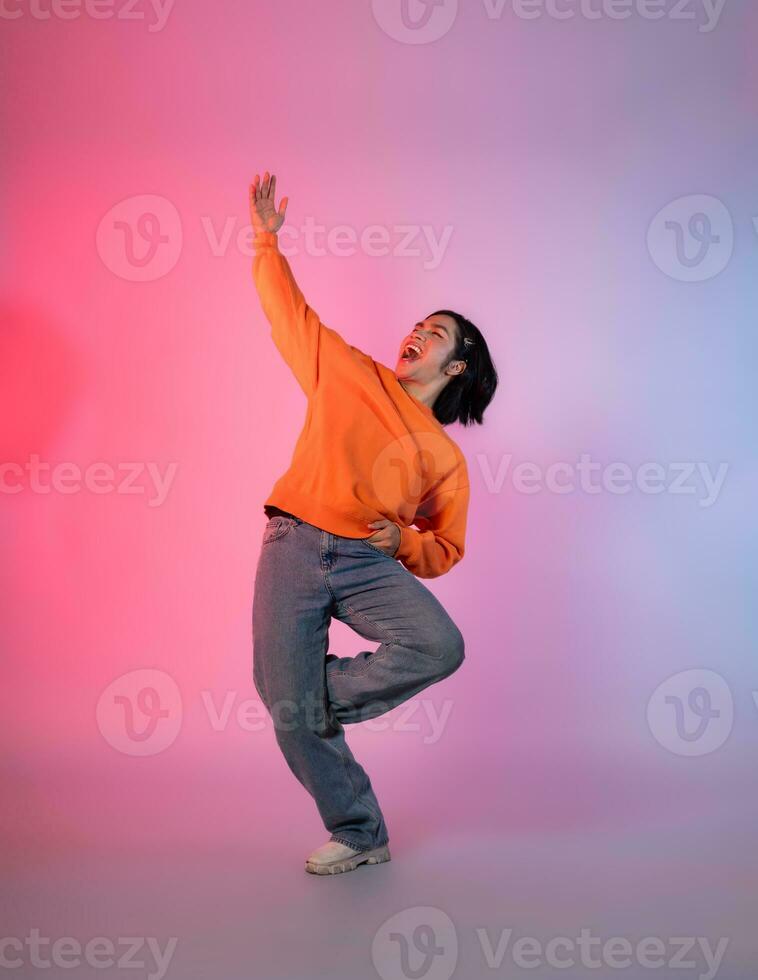 Image of a young Asian person dancing on a neon colored background photo