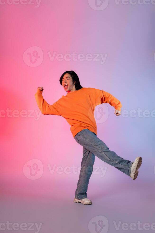 Image of a young Asian person dancing on a neon colored background photo