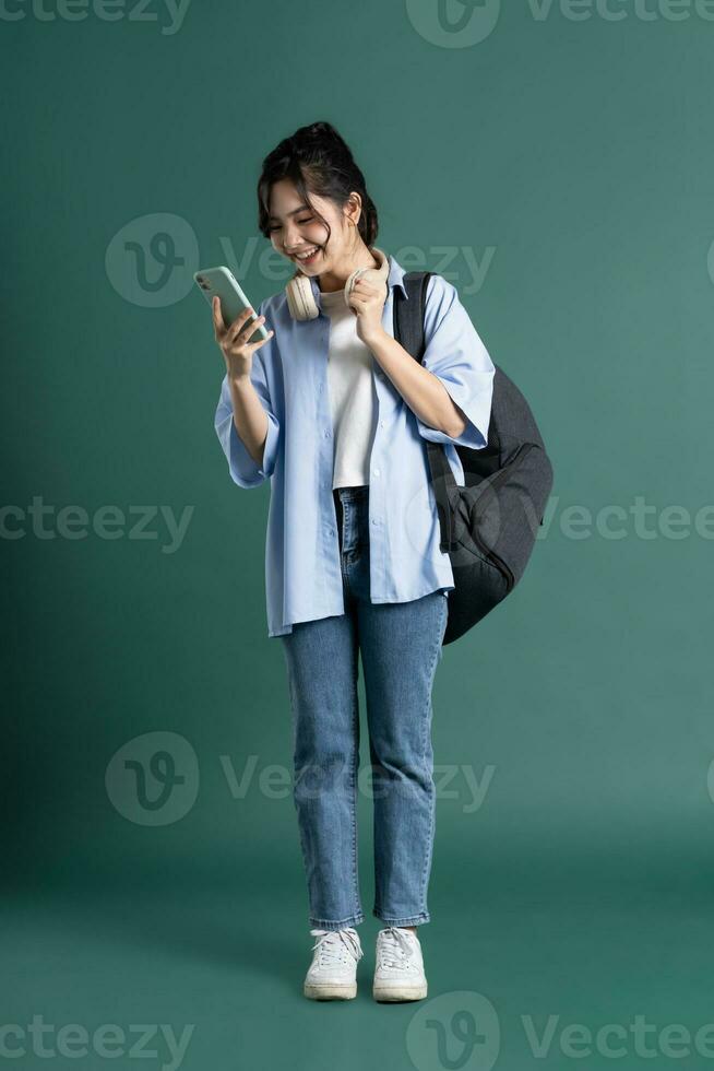 Portrait of a beautiful Asian student on a green background photo