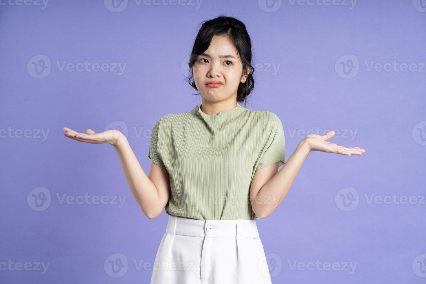Portrait of beautiful Asian girl posing on purple background photo
