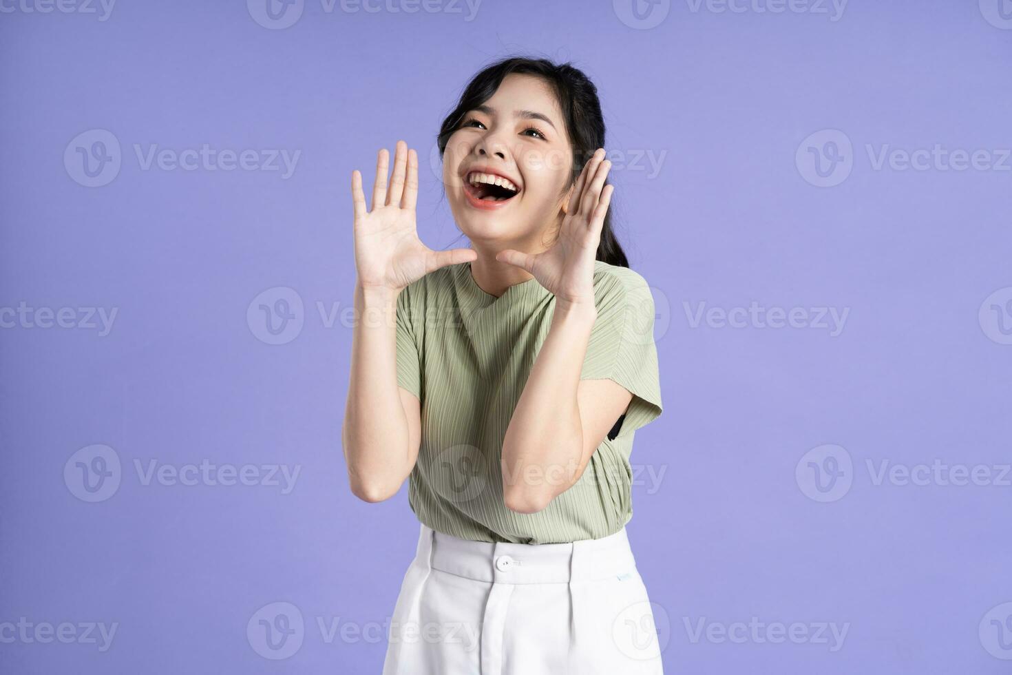 Portrait of beautiful Asian girl posing on purple background photo