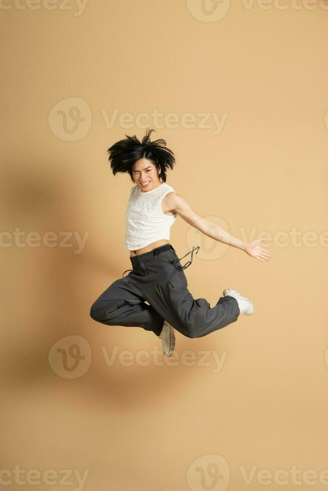 Image of Asian dancer dancing on beige background photo