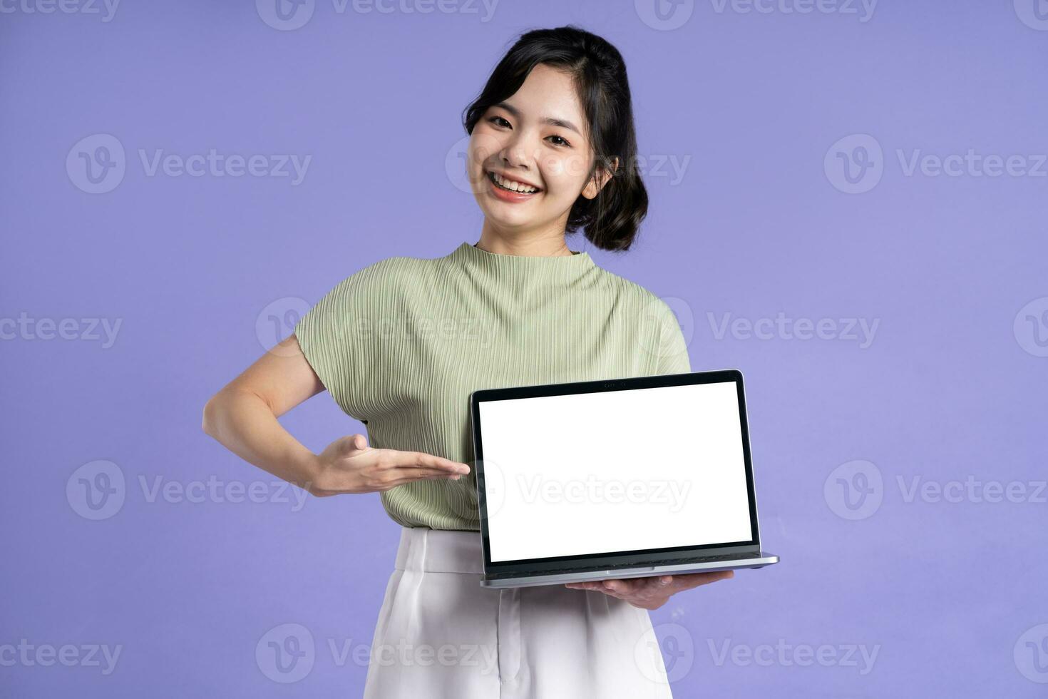 Portrait of beautiful asian woman posing on purple background photo