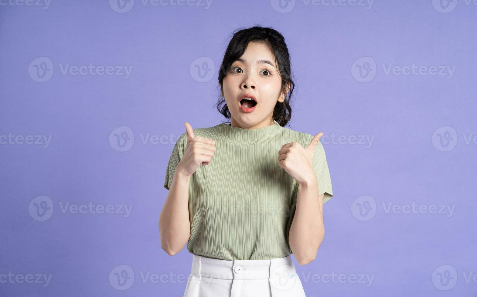 Portrait of beautiful Asian girl posing on purple background photo