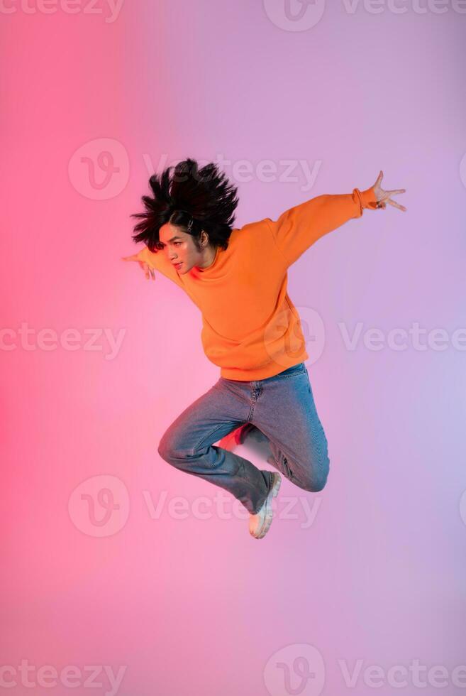 Image of a young Asian person dancing on a neon colored background photo