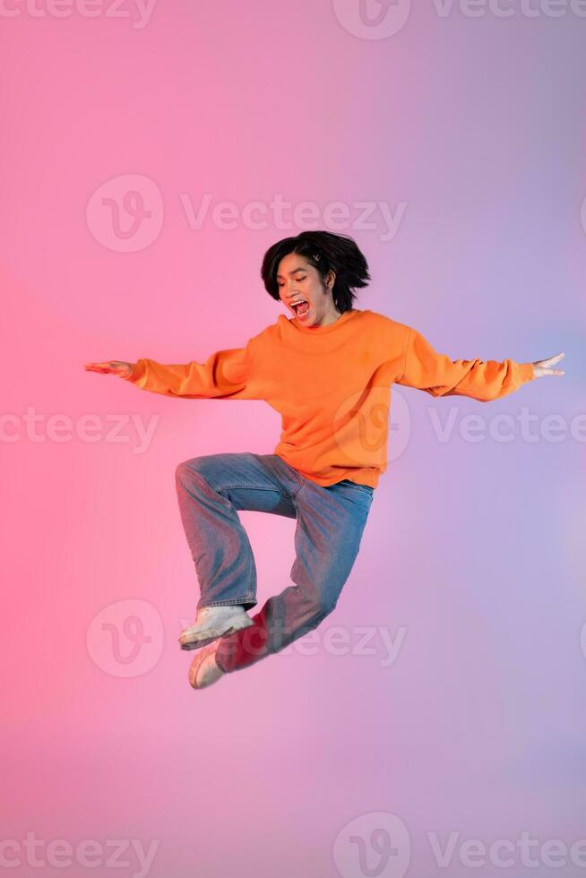 imagen de un joven asiático persona bailando en un neón de colores antecedentes foto