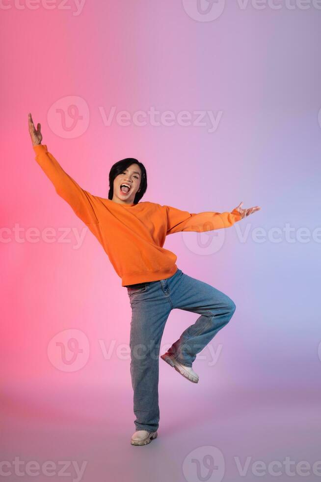 Image of a young Asian person dancing on a neon colored background photo