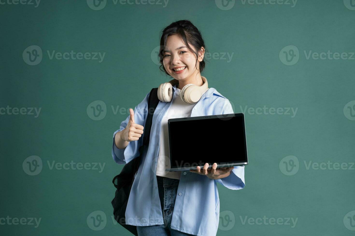 retrato de un hermosa asiático estudiante en un verde antecedentes foto