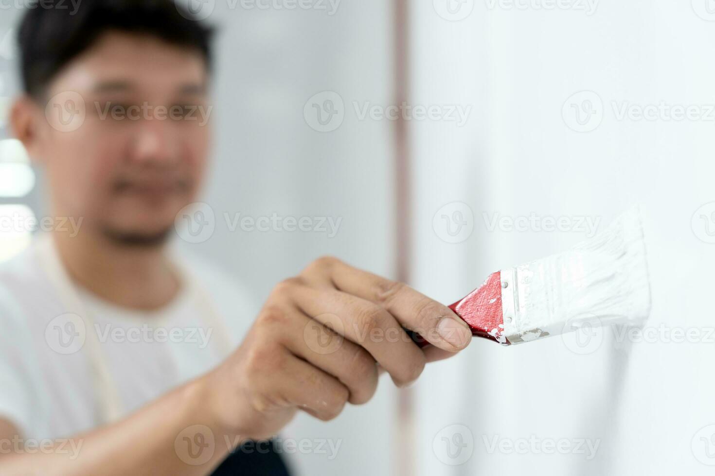 painter man, brush in hand for products to restore and paint the wall, indoor the building site of a house, wall during painting, renovation, painting, contractor, Architect, construction worker photo