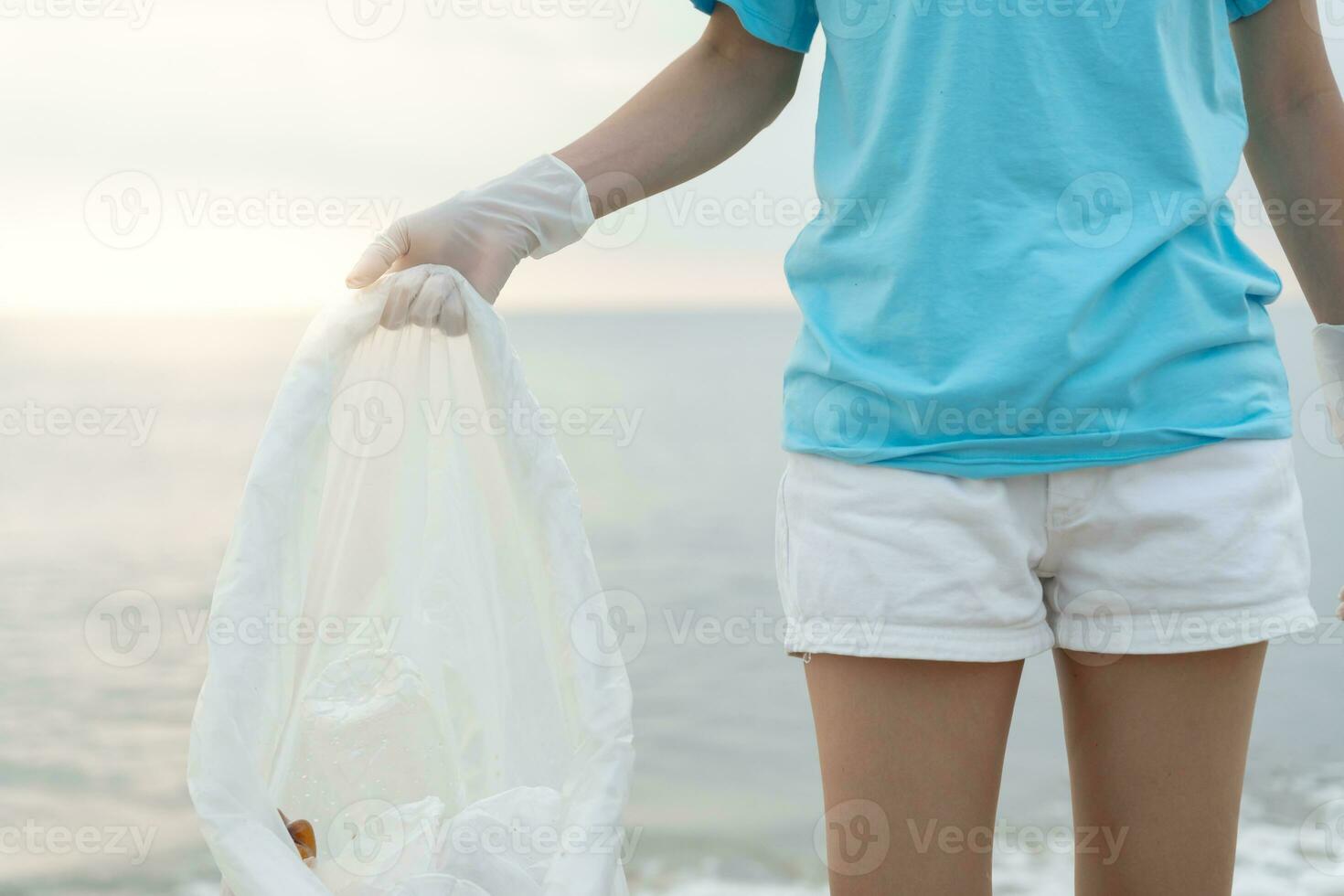 Save water. Volunteer pick up trash garbage at the beach and plastic bottles are difficult decompose prevent harm aquatic life. Earth, Environment, Greening planet, reduce global warming, Save world photo