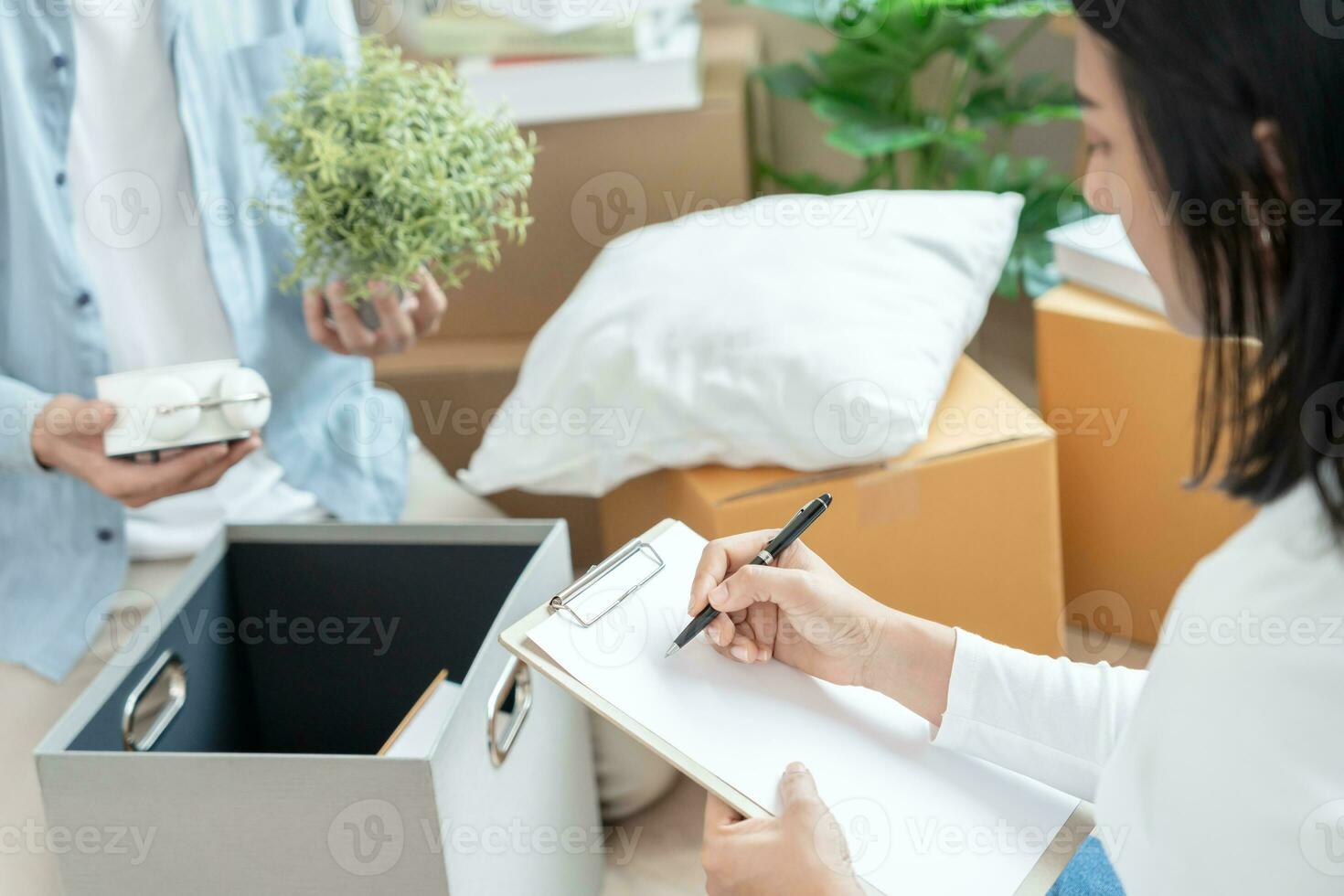 Move house, relocation. wife and husband record quantity furniture for new apartment, Inside the room are cardboard boxes containing personal belongings. Move into a house or condominium photo