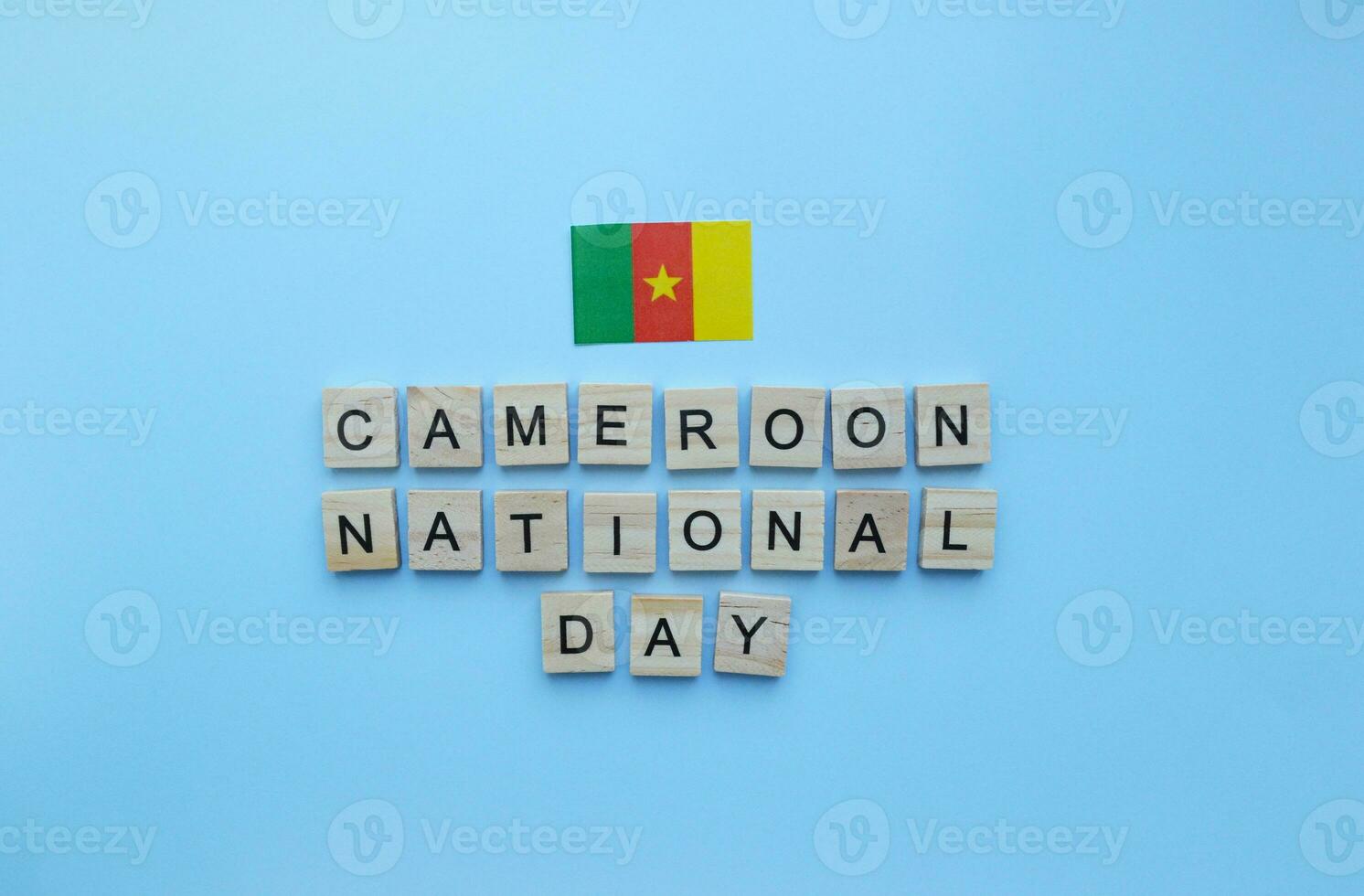 January 1, flag of Cameroon, Independence Day in Cameroon, minimalistic banner with the inscription in wooden letters on a blue background photo