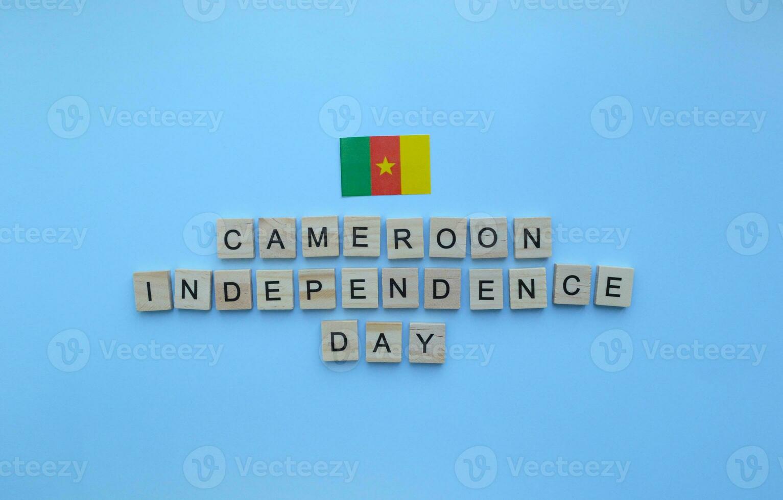 January 1, Independence Day in Cameroon, flag of Cameroon, minimalistic banner with wooden letters on a blue background photo