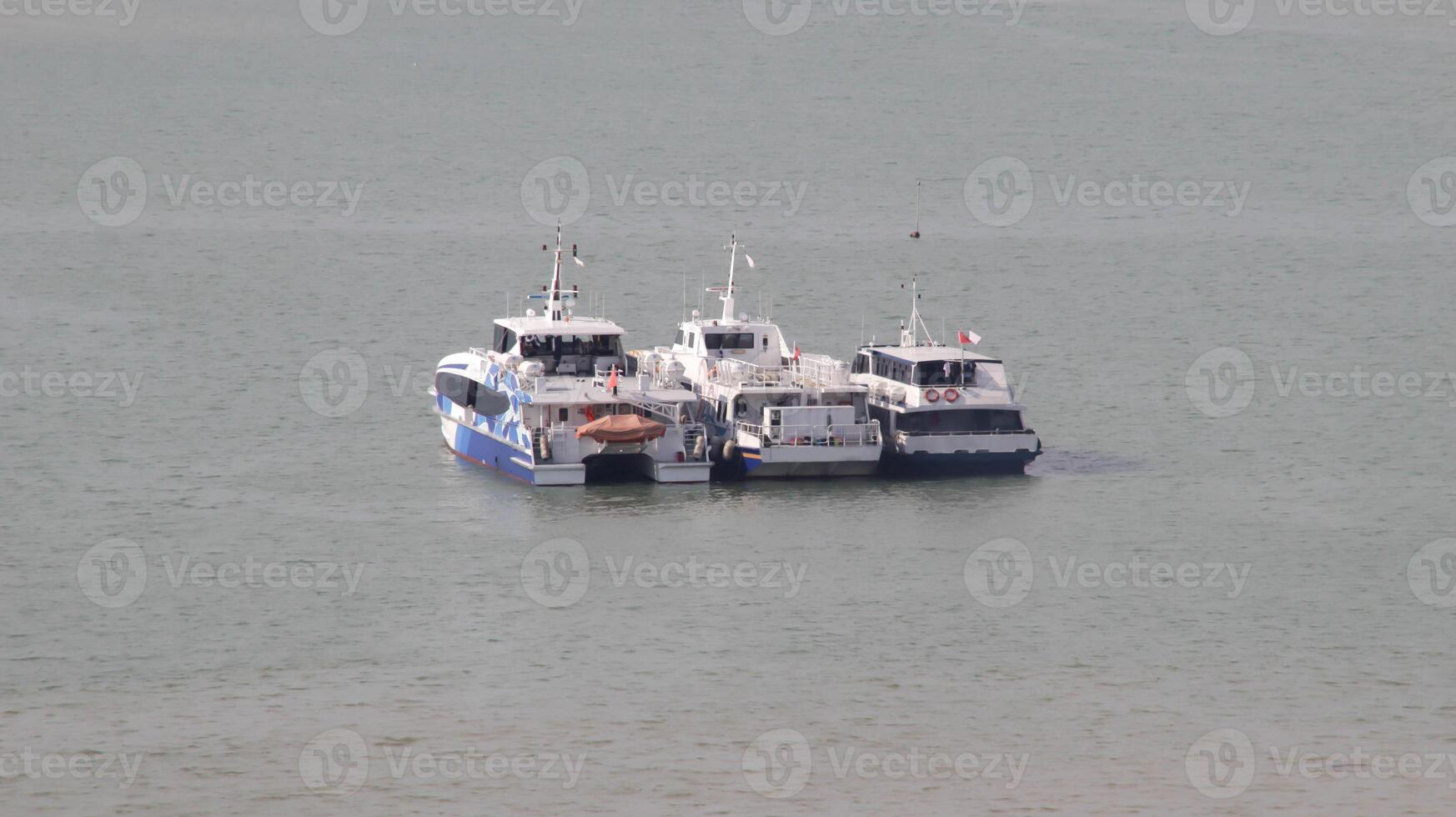 Tres yate amarrado en el medio el océano. foto