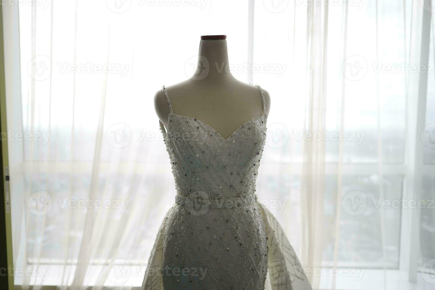 Beautiful White Wedding Dress on a White Mannequin in The Room With Large Window photo