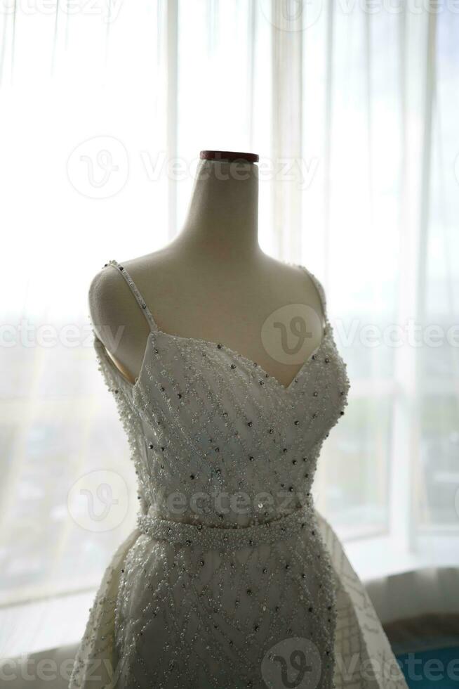 Beautiful White Wedding Dress on a White Mannequin in The Room With Large Window photo