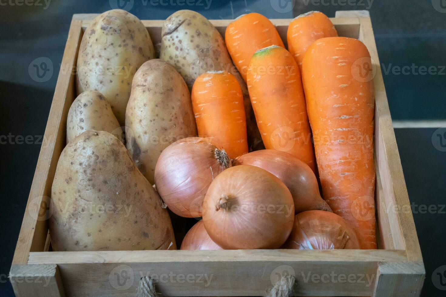 Onion, Carrot and Potato in wood box with studiolight. photo