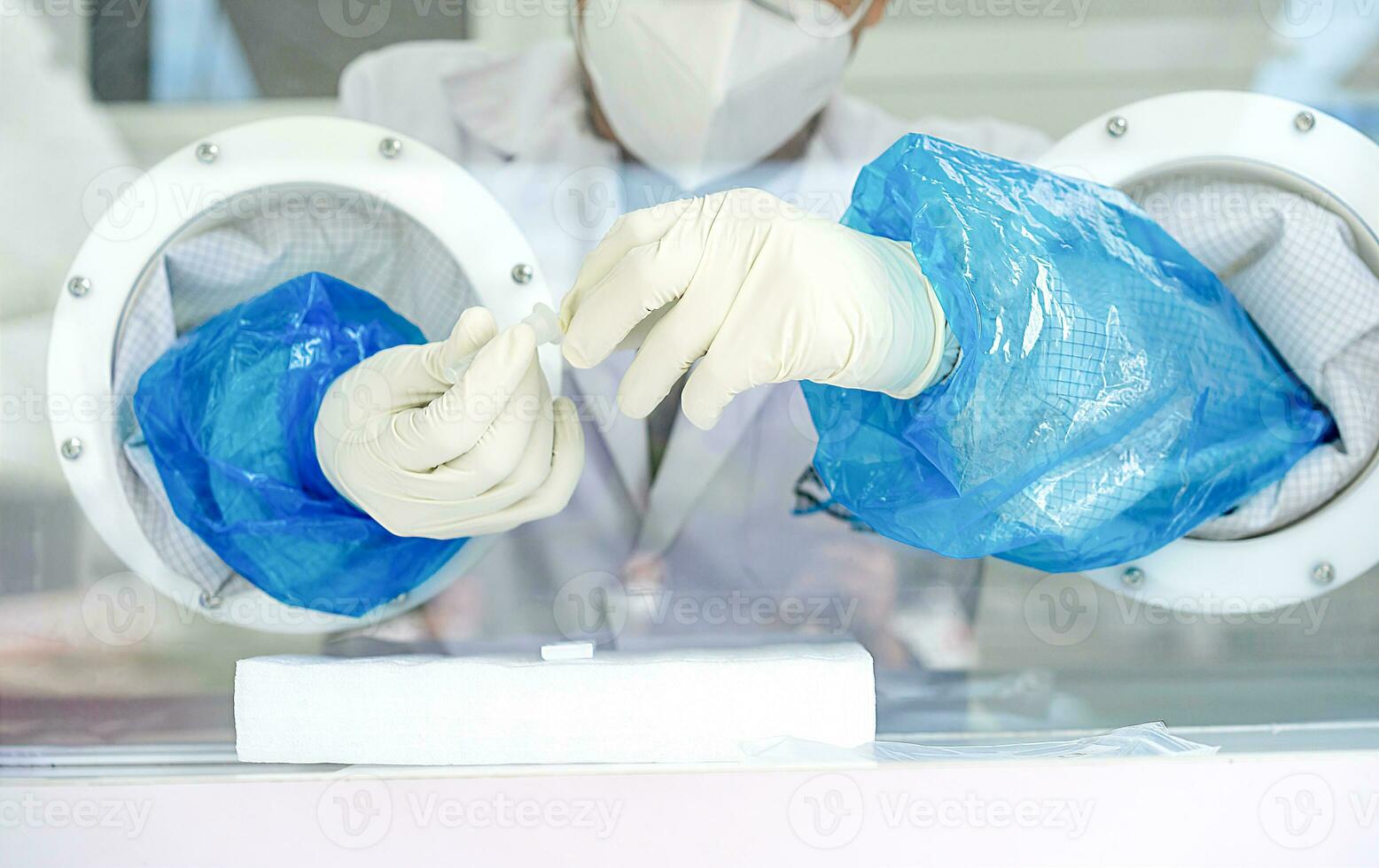 Close up to the rubber gloves on the asian medical staff is processing coronavirus or covid-19 test in the negative room pressure. photo