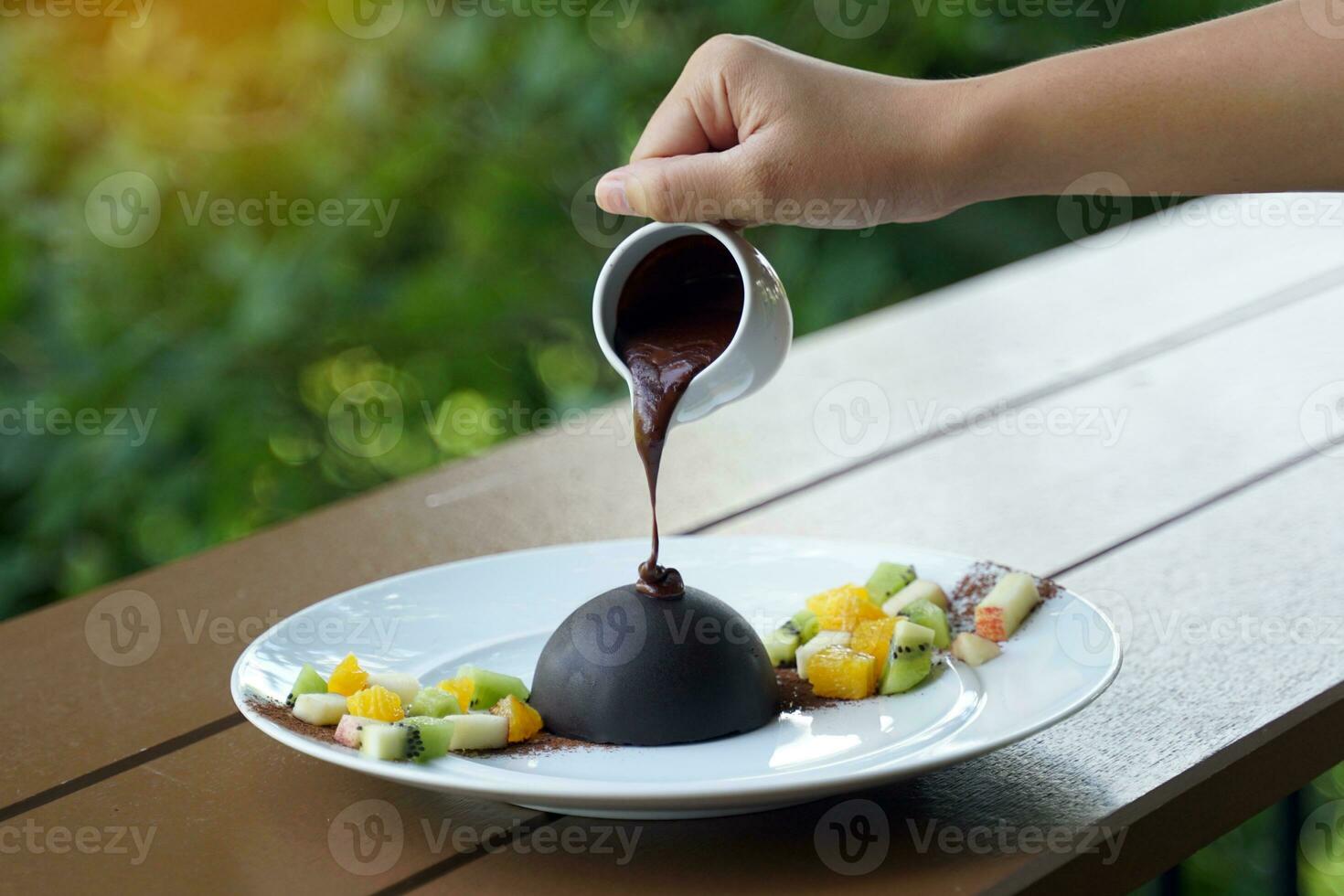 Chocolate dome by covering cookies. Fruit and ice cream of your choice. How to eat, Put warm chocolate on the dome until it melts and you are ready to enjoy the rich ice cream and chocolate lattice. photo