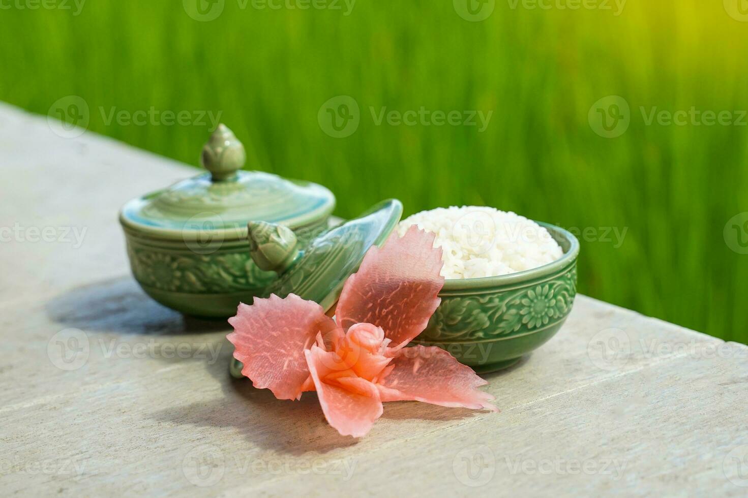 Bowl of steamed rice on green rice field background It is an important staple food for Asian people that must be eaten at every meal with other side dishes. Soft and selective focus. photo