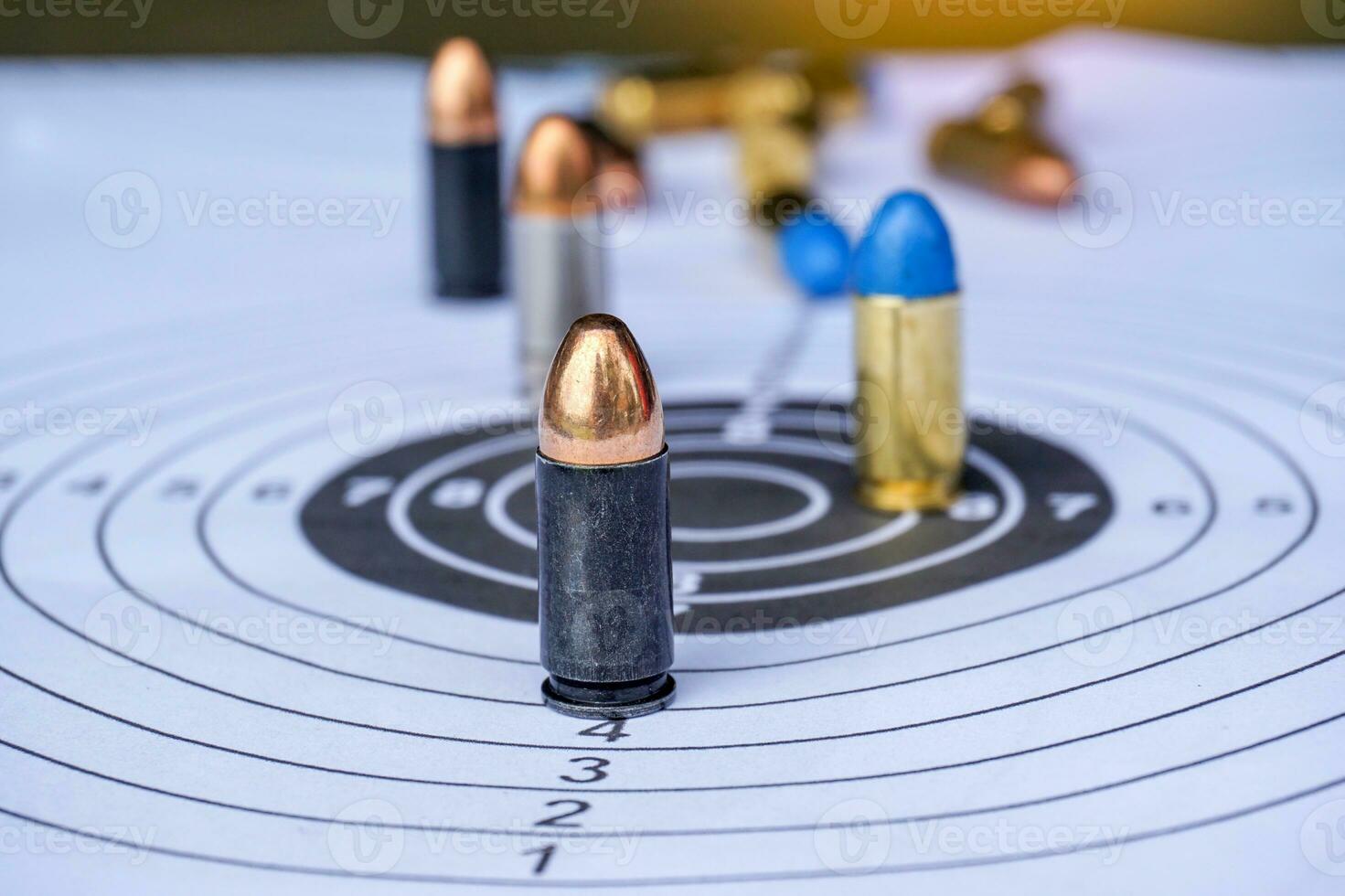 Many bullets on white paper shooting target focus on black bullet The golden bullet head at the front. photo