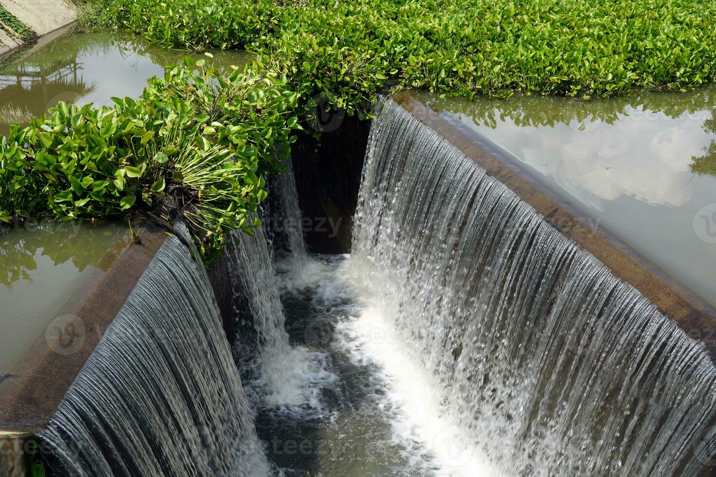 Waterfall from check Concrete dams, which are constructions that block the flow of water, can slow down the flow of water and keep sediment from flowing down and depositing in the river below. photo