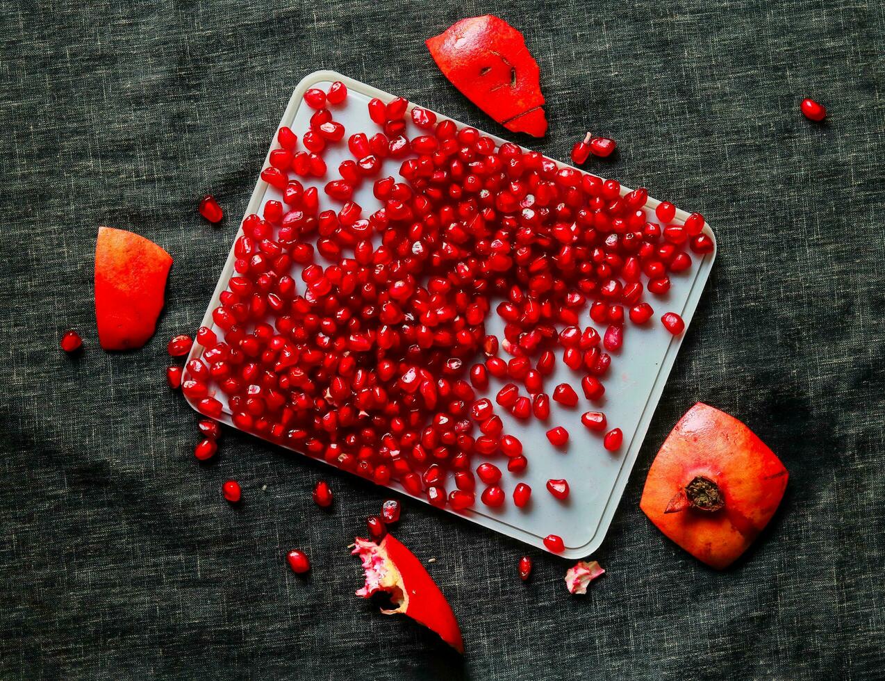 Ripe pomegranate seeds on a plate on a black background photo