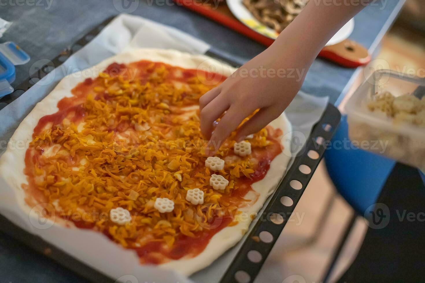 Hand Adding ingredients on homemade pizza. Simple food made from cheap foods. Preparing food at home. photo