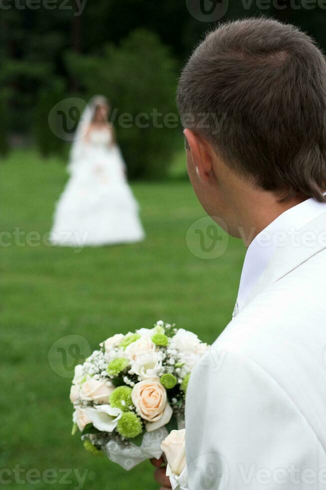 Bouquet of white roses in the hands of the groom photo