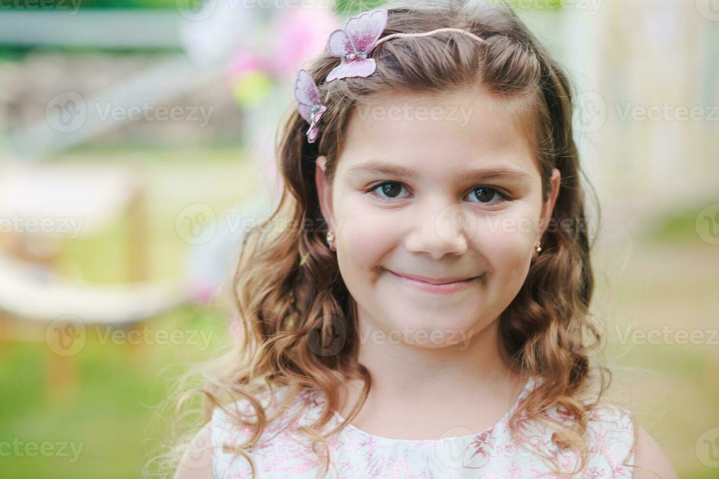 Portrait of a beautiful girl with dark blond hair on the background of a swing decorated with flowers photo