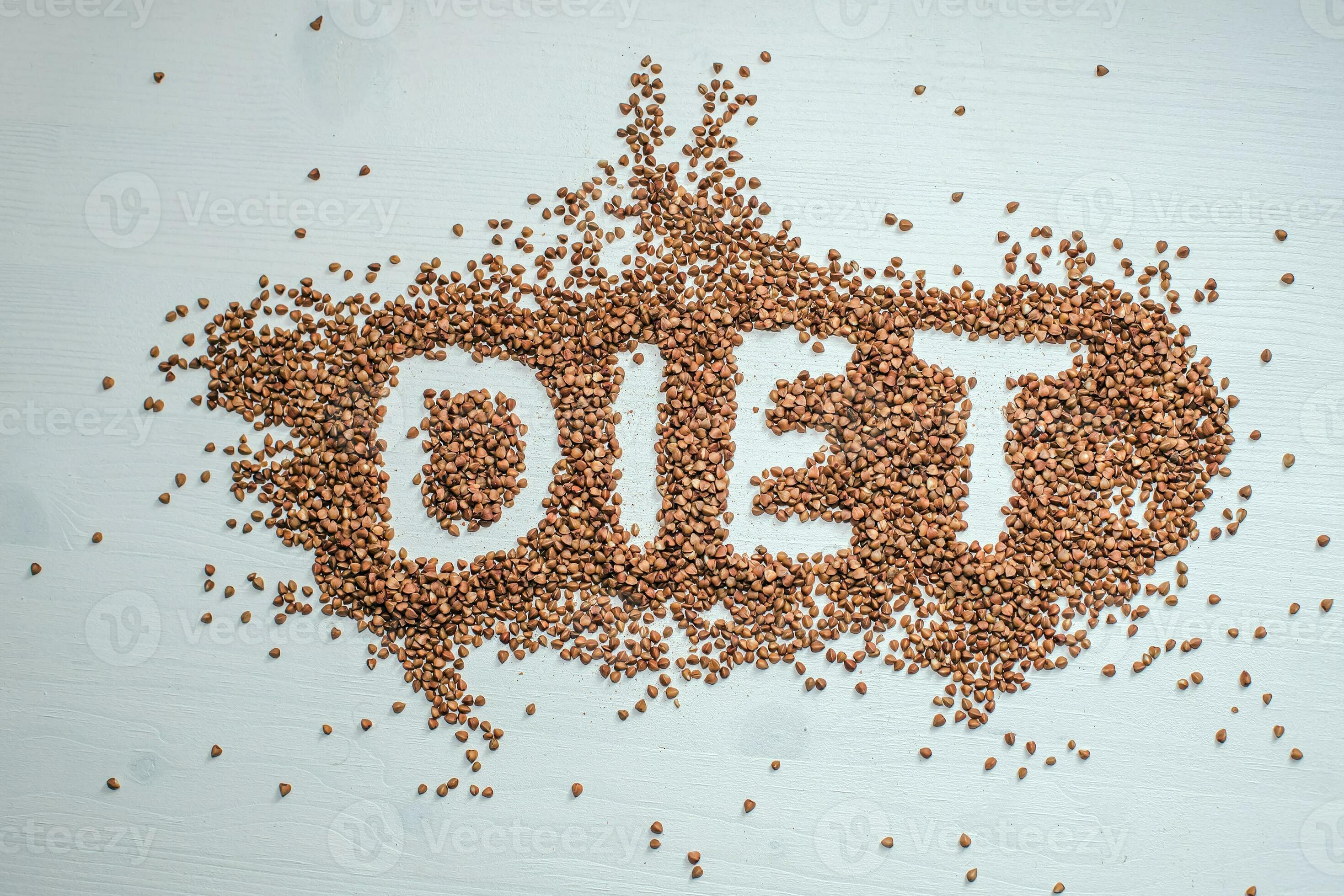 buckwheat diet. Scattered on wooden white background of grit. word