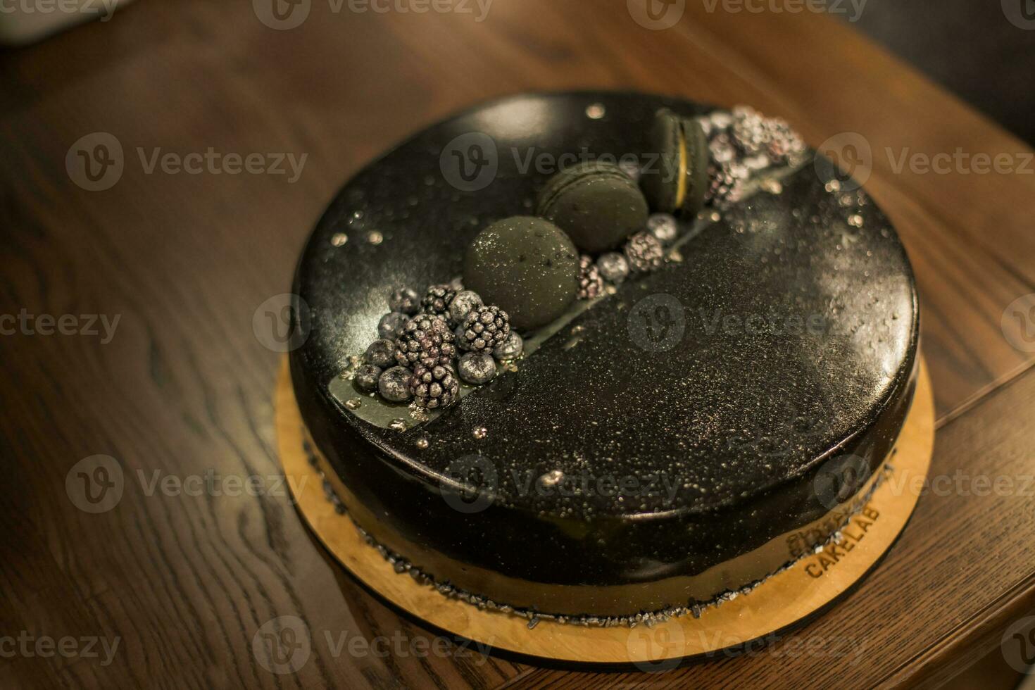 Black chocolate cake on a wooden table. Decorated with chocolate chip cookies birthday cake on a restaurant photo