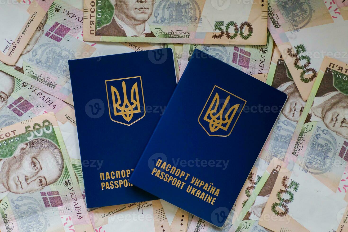 dos internacional pasaporte de ucranianos mentira en pila de dinero desde cinco cien libras Billetes pasaportes para salida a Europa sin visas. sin visa régimen para Ucrania. foto