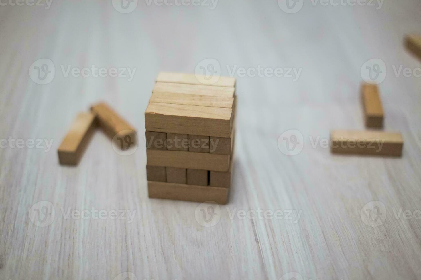 Tower of wooden blocks on the bright floor. Wooden sticks scattered with children's games. photo