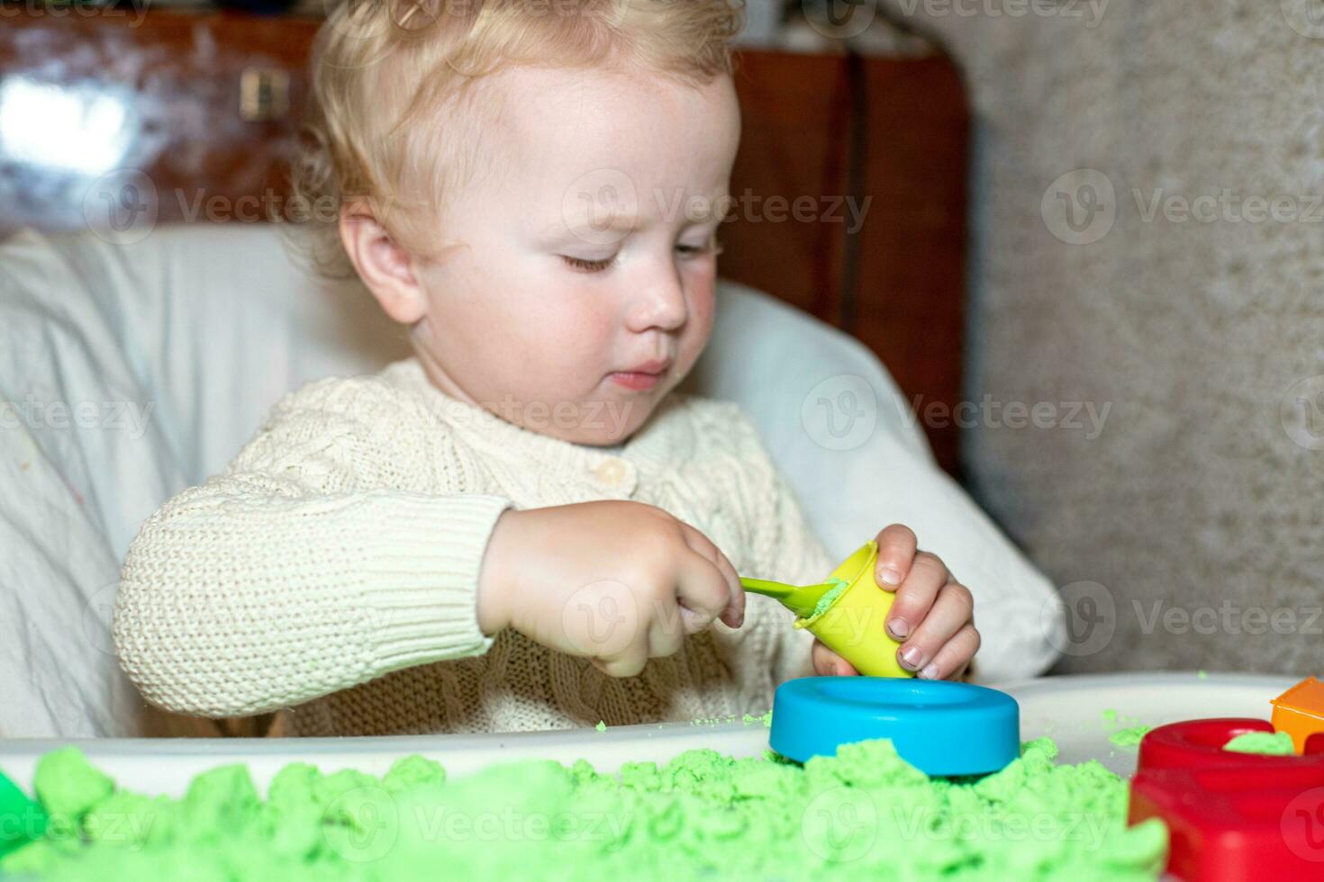 girl plays with kinetic sand. child builds shepherds in form of letters of sand. Early development of children. fine motor skills of the fingers. photo