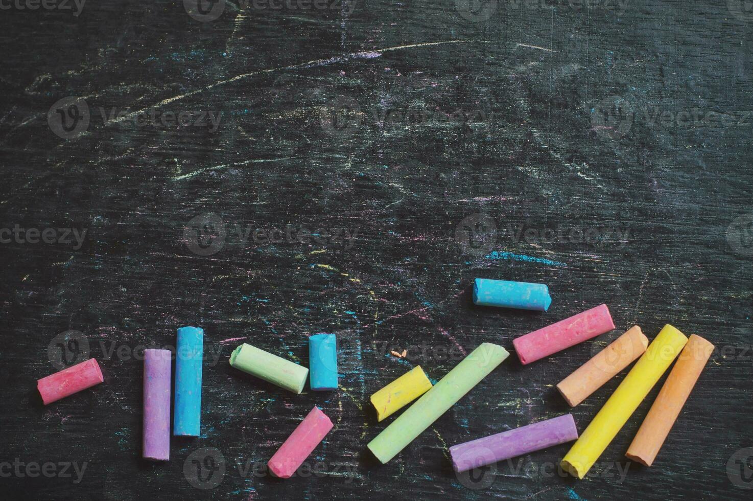 Multicolor chalk on backboard for education background photo