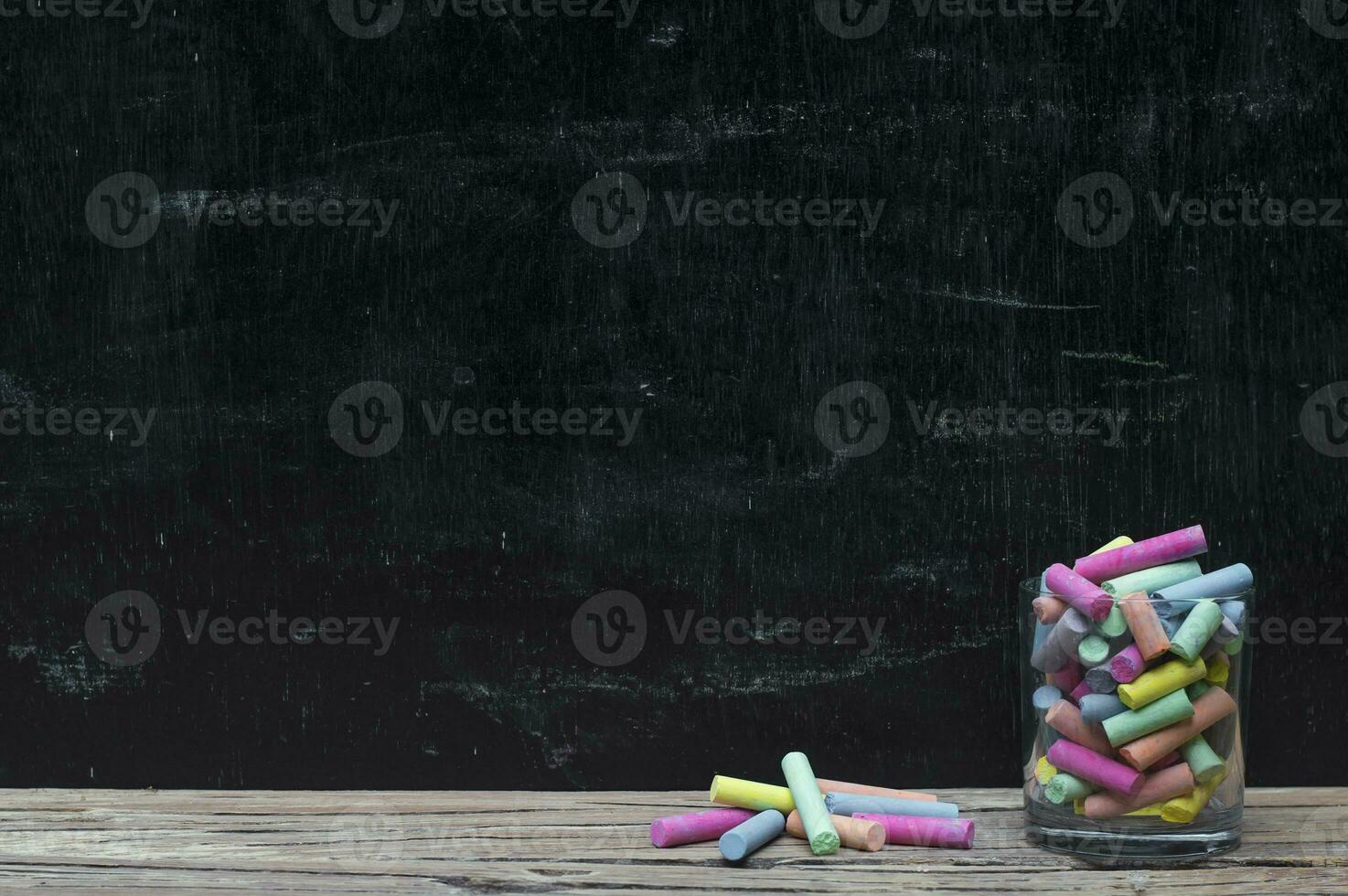 Multicolor chalk on wooden with backboard for education background photo