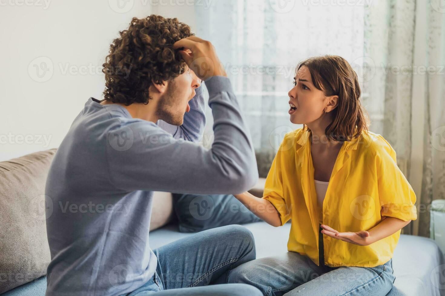 Man and woman are sitting at sofa and arguing. Relationship problems. photo