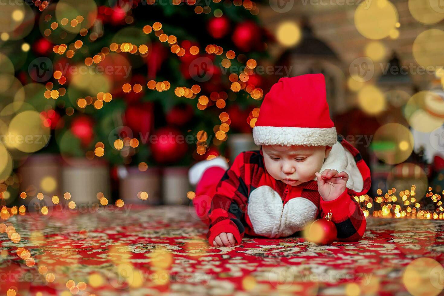 Little six month old baby dressed as Santa Claus. Background for christmas card. The child looks down at the place for inscription. photo