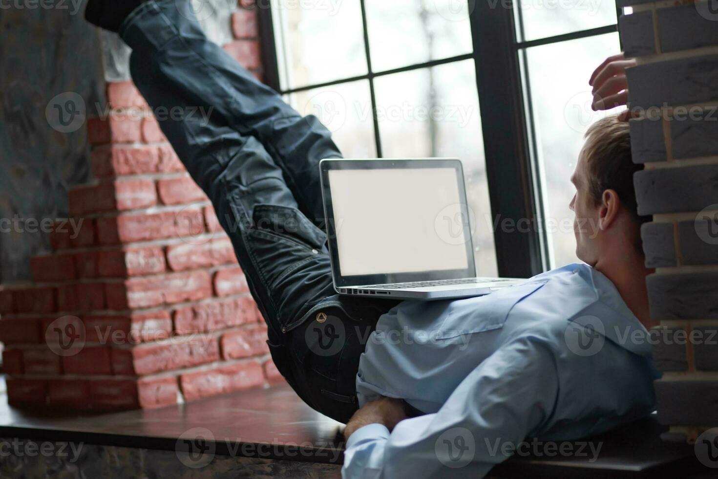 A man looks at a blank computer screen display. The man lies on photo