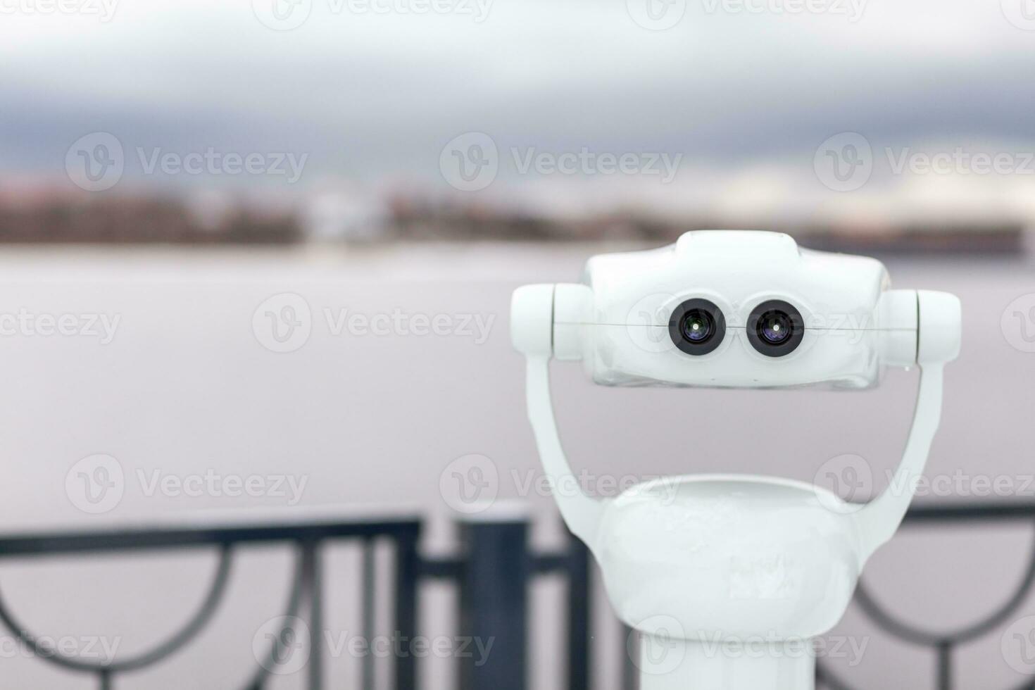 Public stationary binoculars on the riverbank to look at nature photo