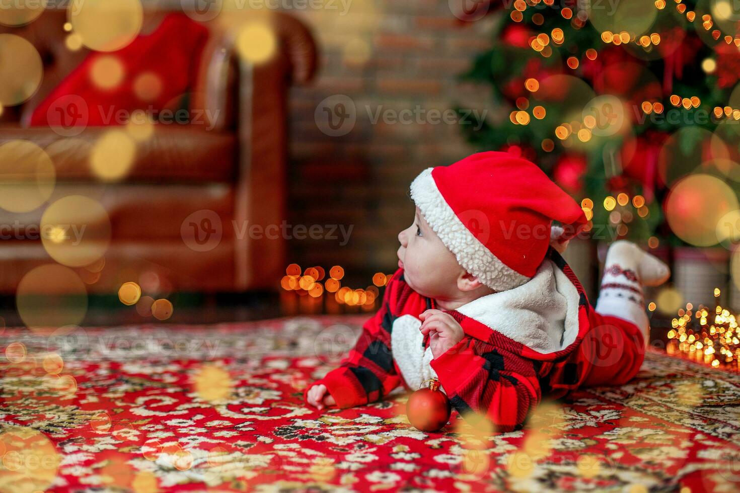 pequeño seis mes antiguo bebé vestido como Papa Noel noel antecedentes para Navidad tarjeta. el niño mira arriba a el sitio para inscripción. foto