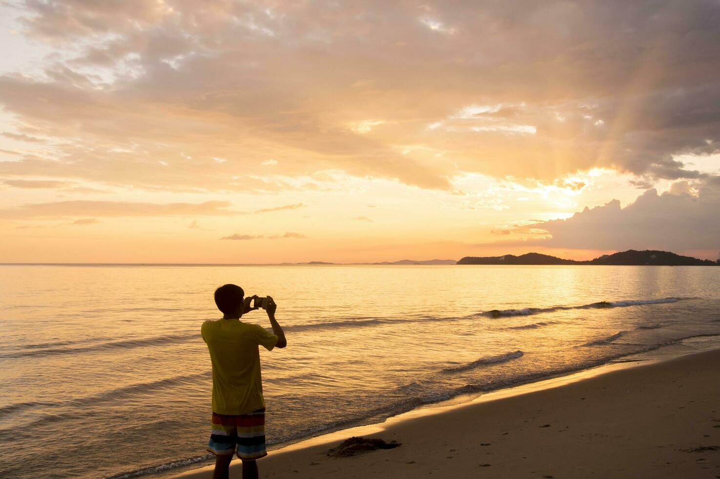 Silhouette of man keep memories with camera phone in his hand photo