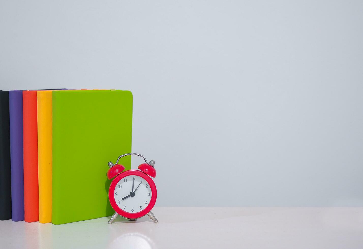 Red alarm and colorful hardcover book, Copy space for text, Back to school, Education concept photo