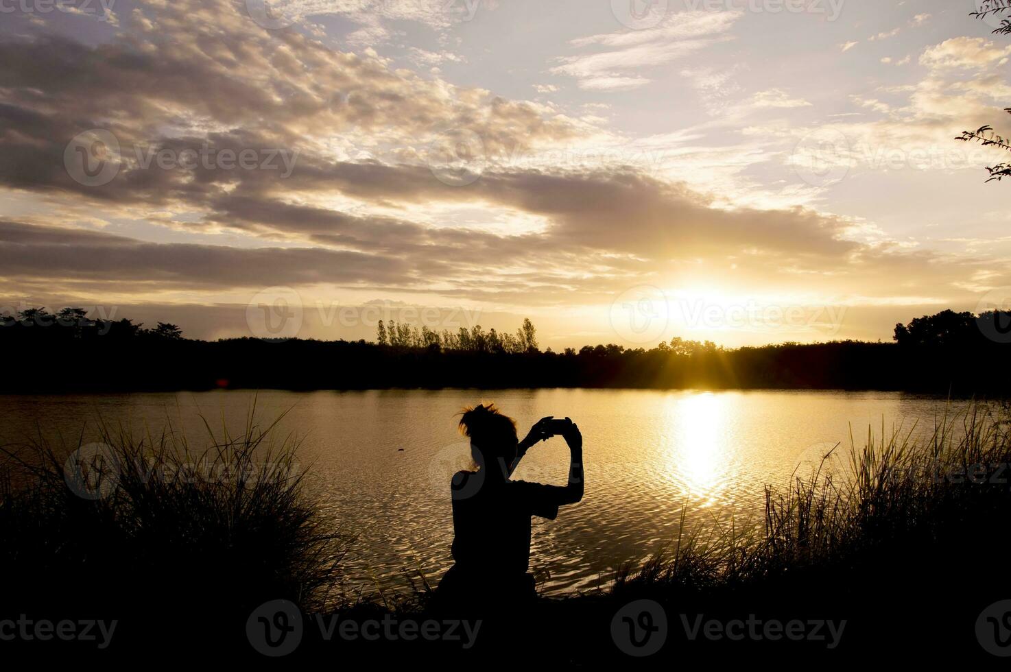 silueta de mujer tomando imagen a el lago foto