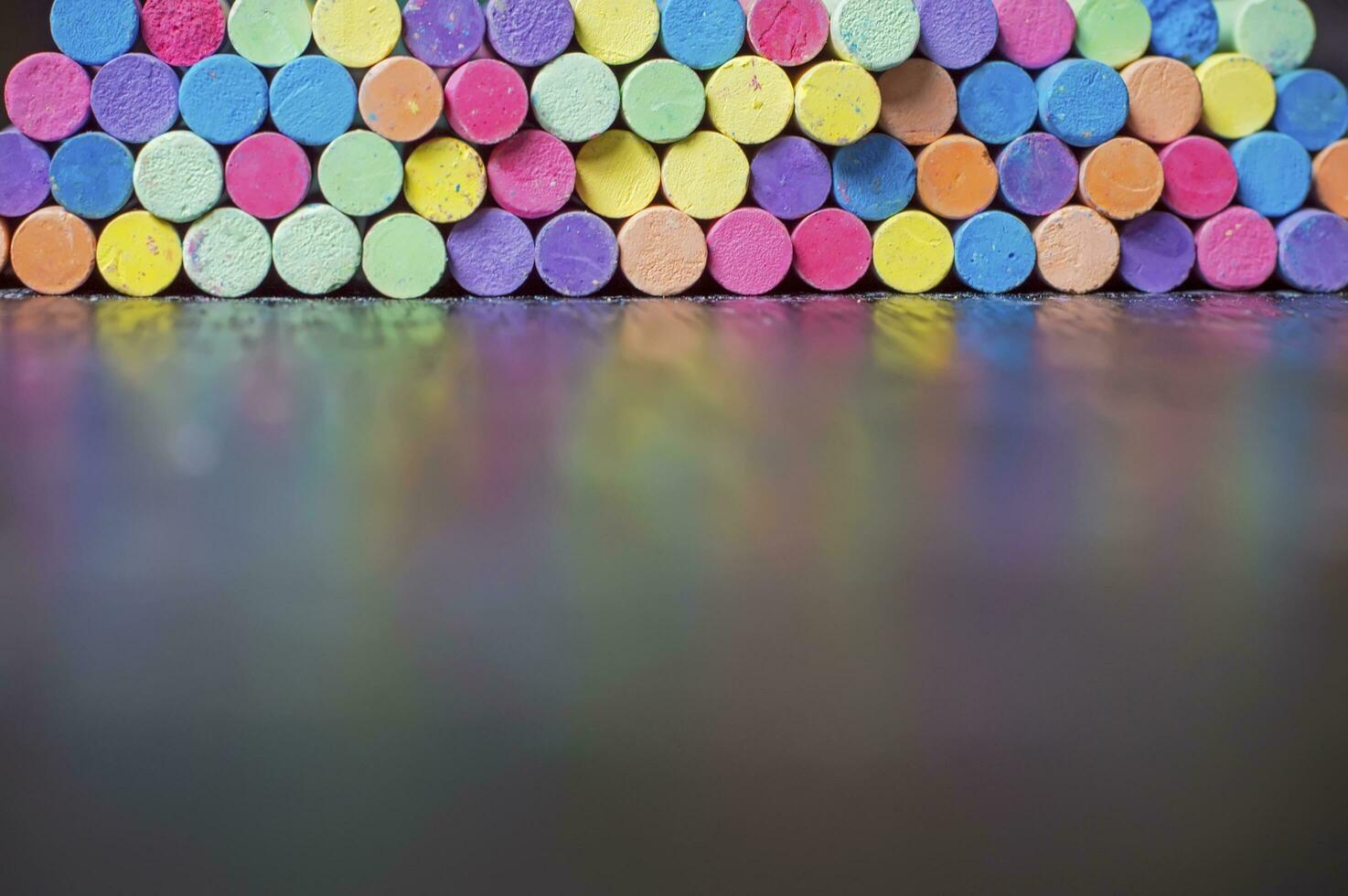 Blurry multicolor chalk on desk for education background photo