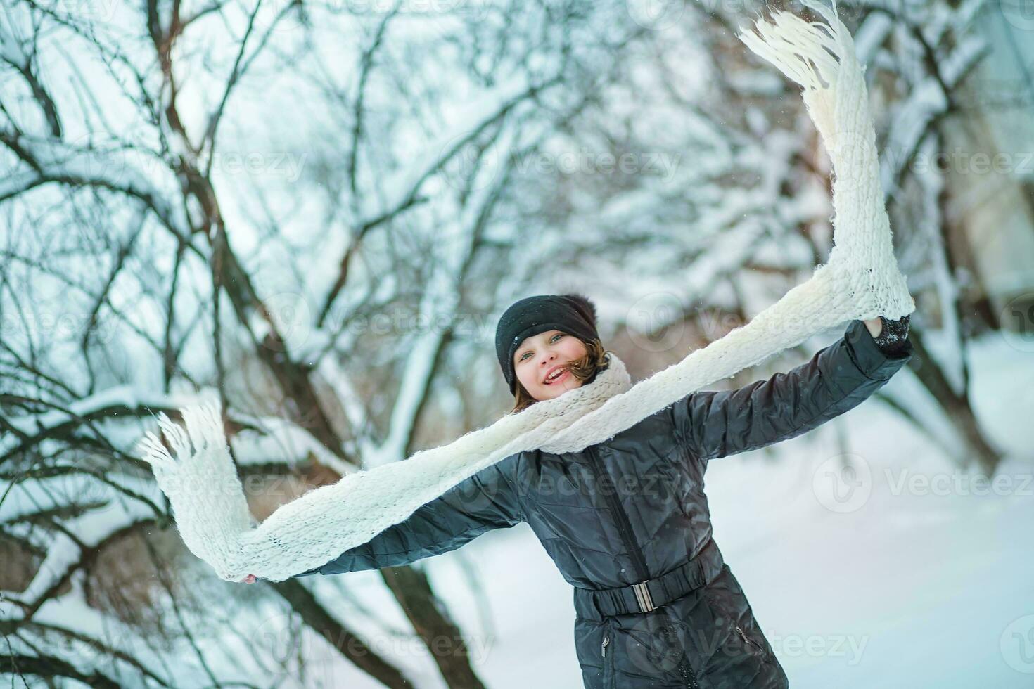 The girl holds a large white scarf. Snowfall in the city. photo