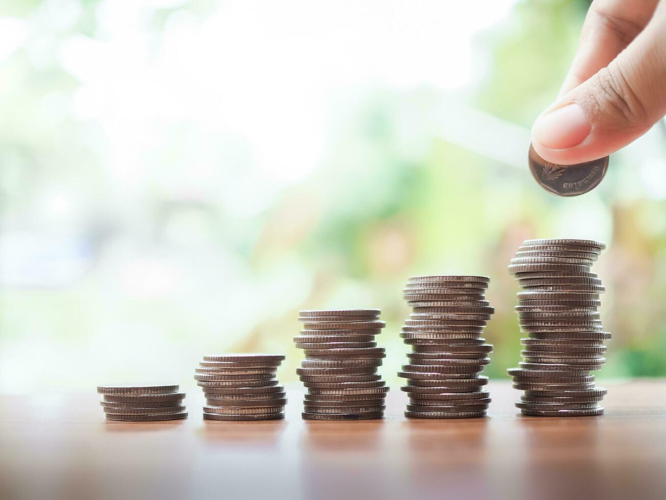 Close up hand putting coin in stack of coins.The concept of save money for prepare in the future. photo