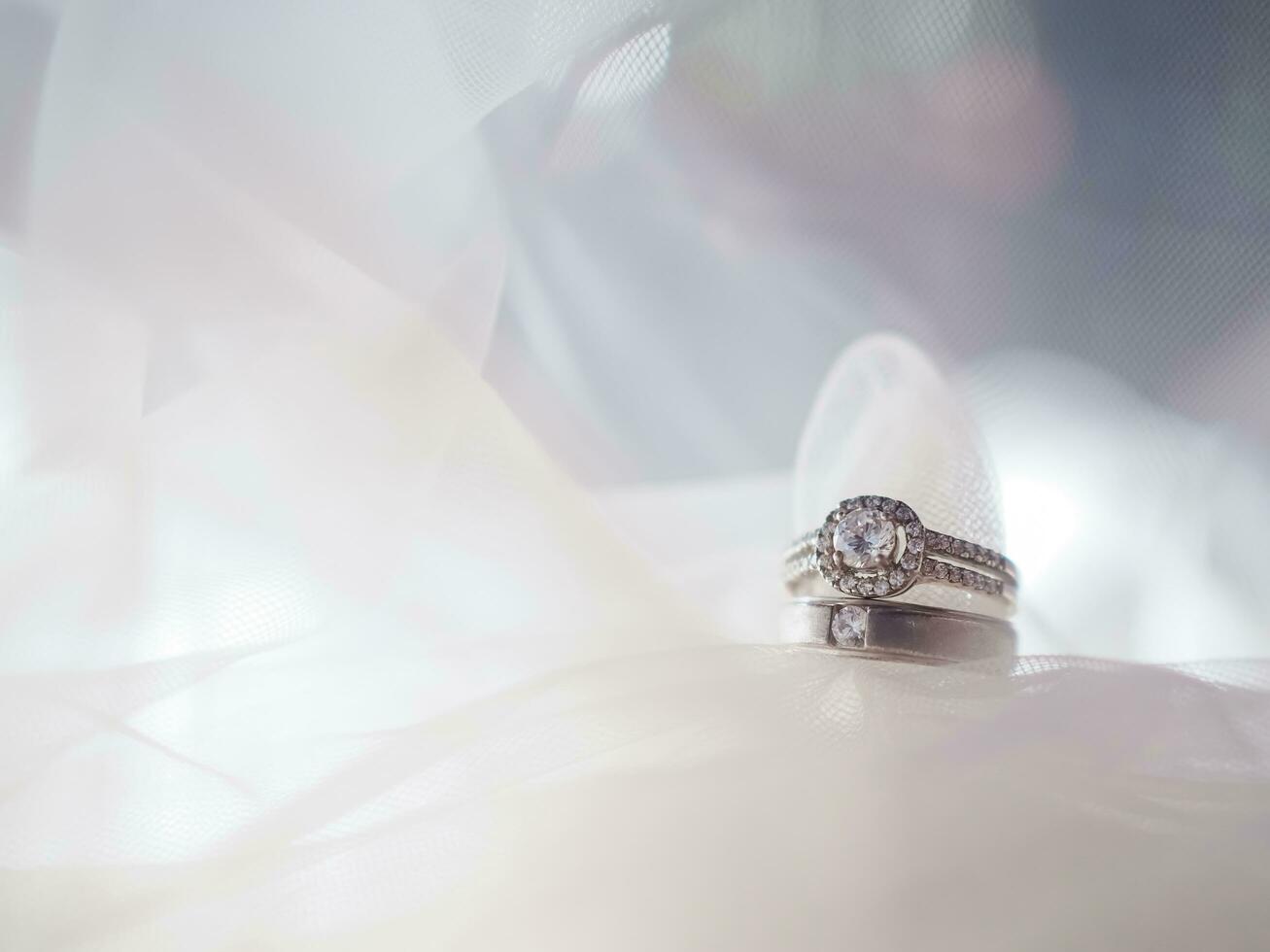 Diamond engagement wedding rings on bridal veil. Wedding accessories, Valentine's day and Wedding day concept. photo
